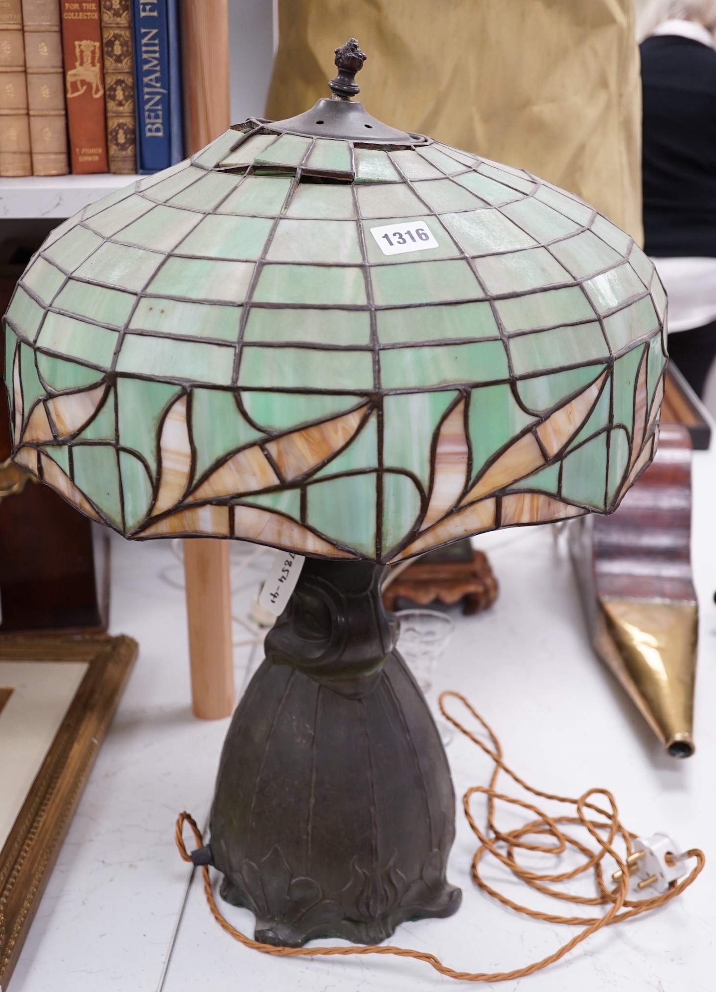 A spelter lamp with Tiffany style shade, 57cms high including shade